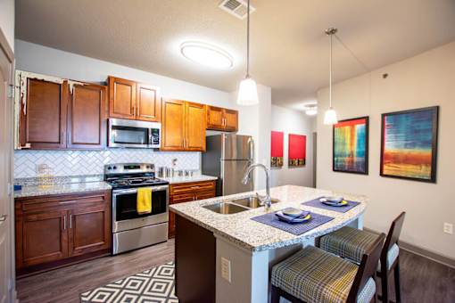 A kitchen with a white counter top and a stainless steel refrigerator.