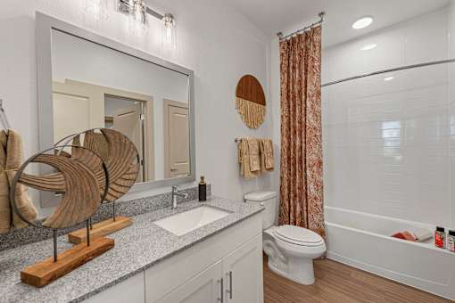 A bathroom with a white toilet, a wooden sculpture, and a shower curtain.