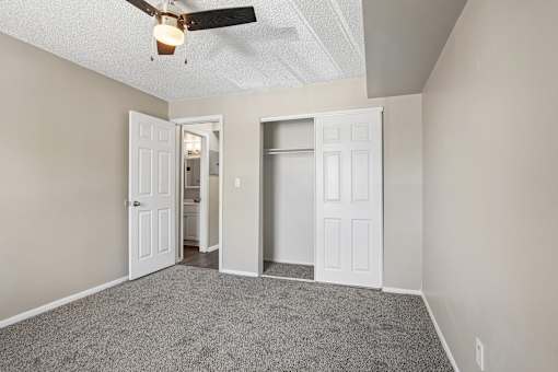 A room with a ceiling fan and two doors.