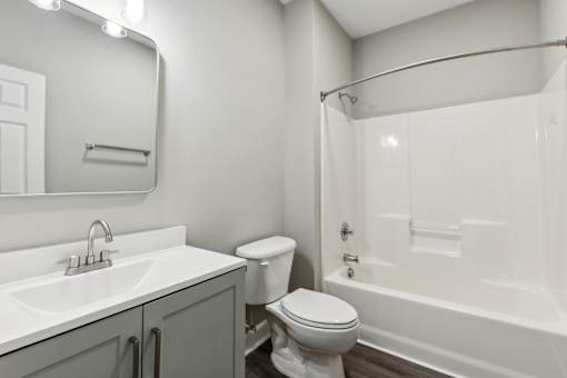 A white bathroom with a toilet, sink, and bathtub.