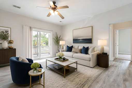 A living room with a blue armchair, a white couch, and a coffee table.