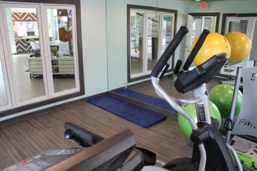 a gym with a treadmill and other exercise equipment at Elevate at Huebner Grove, San Antonio, Texas