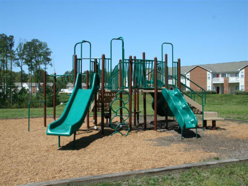 a playground with two slides and a jungle gym at Chester Village Green Apartments, Chester, Virginia