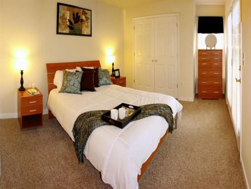 a bedroom with a bed and two dressers at Chesterfieldfield Garden Apartments, Virginia, 23836