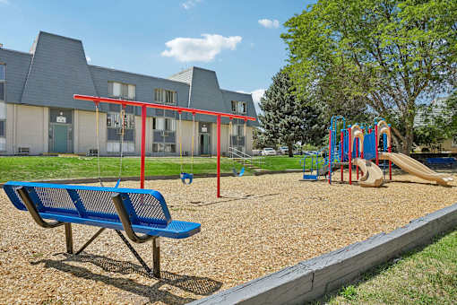 A playground with a blue bench and a slide.