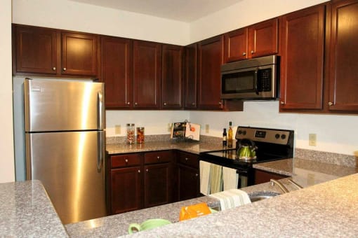 a kitchen with stainless steel appliances and granite counter tops at Chester Village Green Apartments, Chester, VA