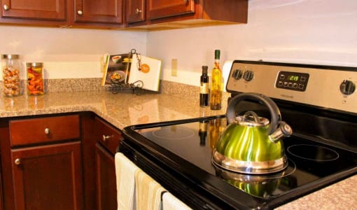 a kitchen with a stove and a kettle on the stove at Chester Village Green Apartments, Chester, VA