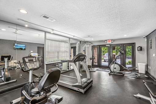 A gym with treadmills, elliptical machines, and other exercise equipment.