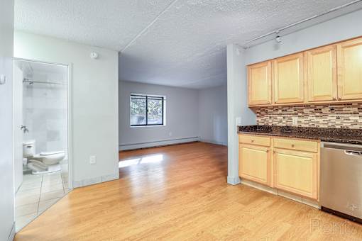 Bright kitchen with wooden cabinets and a stainless steel dishwasher at Summit Terrace, South Portland, ME, 4106