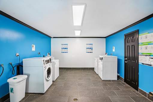 A laundromat with a blue wall and a black door.