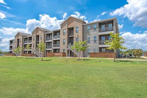 A large apartment complex with multiple buildings and green lawns in front.