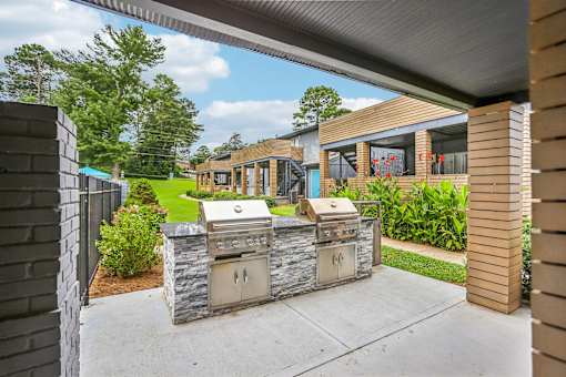 A modern outdoor kitchen with a grill and sink.