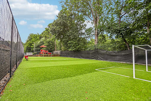 A tennis court surrounded by a black fence.