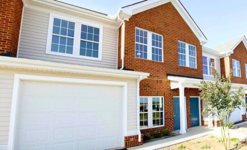a large brick house with a white garage door at Chester Village Green Apartments, Chester