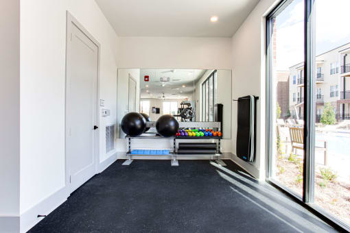 the gym with large windows and black carpeted flooring