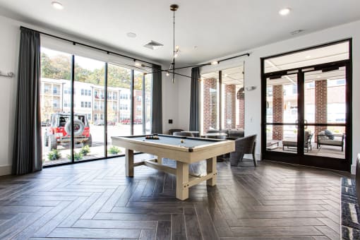 a game room with a pool table and sliding glass doors