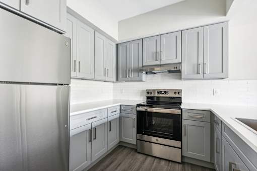 A modern kitchen with a stainless steel refrigerator and oven.