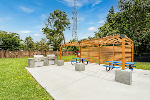 A wooden pavilion with a picnic table and concrete blocks in the foreground.