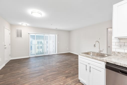 a kitchen and living room with a sink and a window