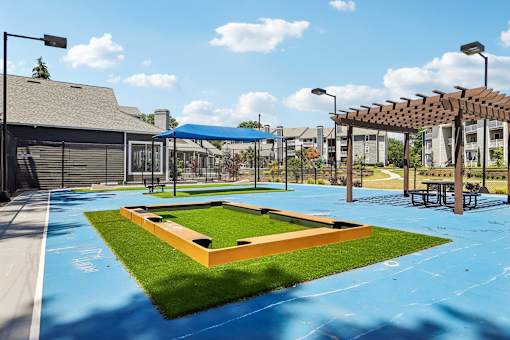 A playground with a blue surface and a wooden structure.