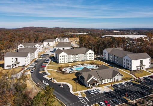 an aerial view of a large hotel complex with a swimming pool and parking lot