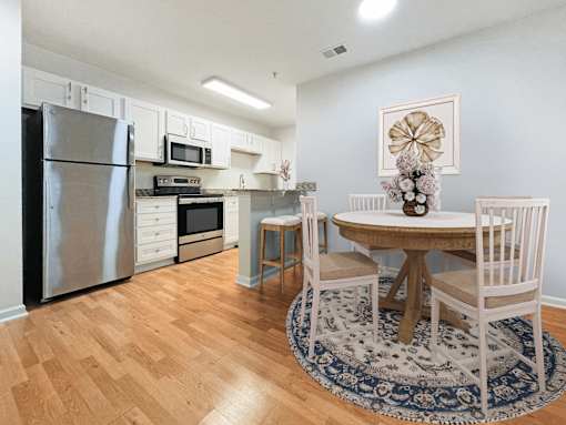 a kitchen and dining room with stainless steel appliances and a round table