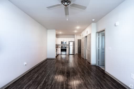 a living room with white walls and a ceiling fan