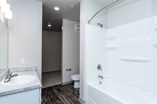 a bathroom with a white bathtub and a white sink