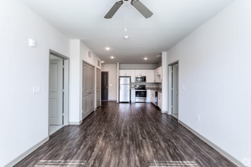 a living room with white walls and a ceiling fan