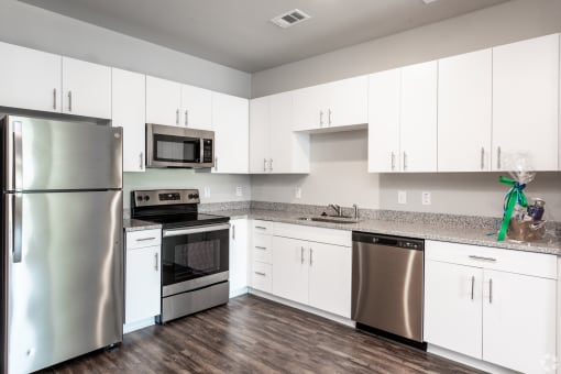 a kitchen with white cabinets and stainless steel appliances