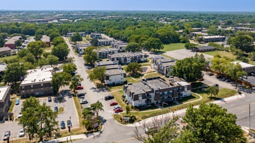 an aerial view of a neighborhood of houses with trees in the background
