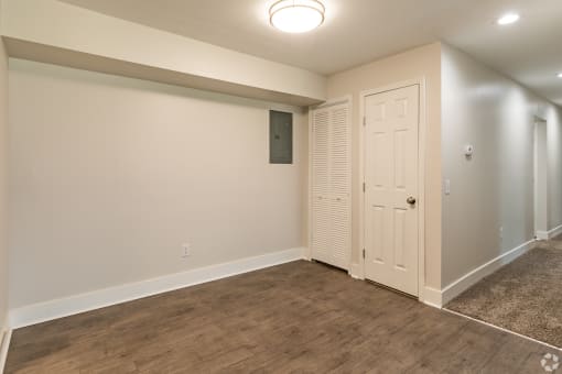 a bedroom with a door and a carpeted floor