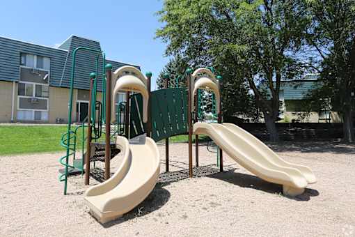 A playground with a slide and a climbing frame.
