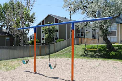 A swing set with two swings and a blue bar.