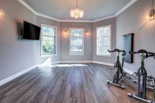 a workout room with a exercise bike and a tv