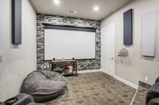 a living room with a projector screen and a couch