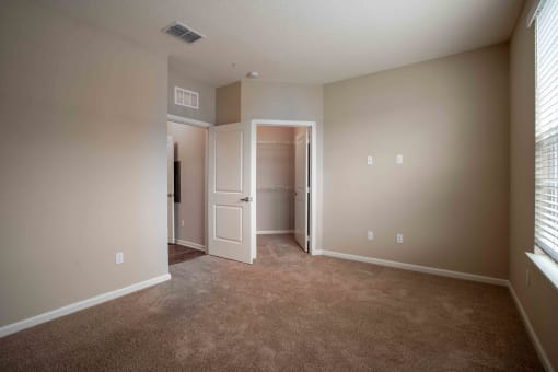 a living room with carpet and a door to a closet