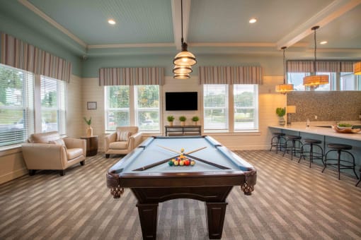 a game room with a pool table and a bar