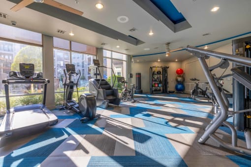 a gym with weights and cardio equipment on a blue and white tile floor