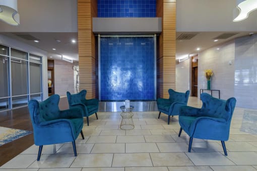 the lobby of a hotel with blue chairs and a blue wall
