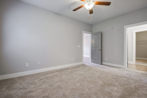 a bedroom with gray walls and a ceiling fan