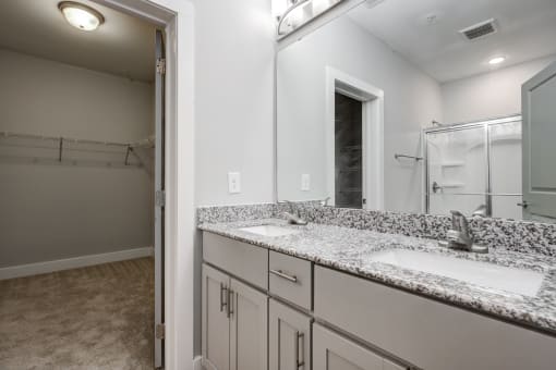 a bathroom with granite countertops and a large mirror
