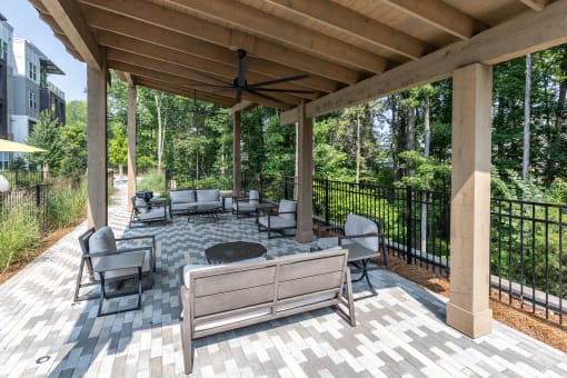 a covered patio with couches and chairs