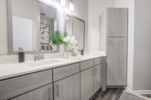 a bathroom with gray cabinets and white countertops
