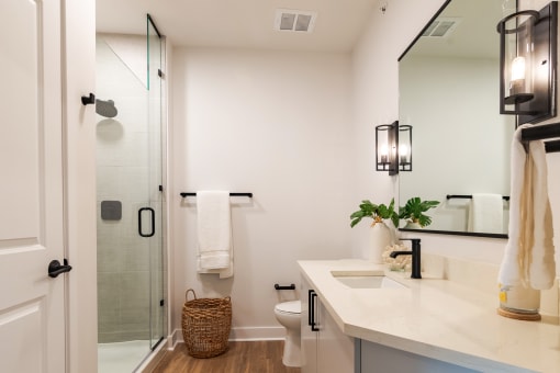 a bathroom with white walls and a large mirror