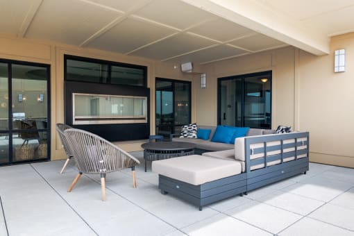a seating area with a sofa chair and ottoman on a patio