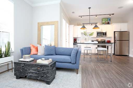 A living room with a blue couch and a coffee table.