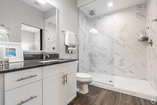 A bathroom with a marble wall and a toilet.