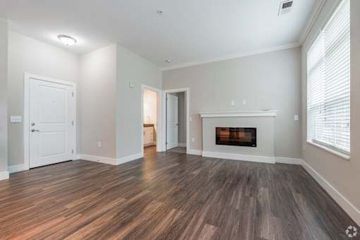 A room with a fireplace and wood flooring.