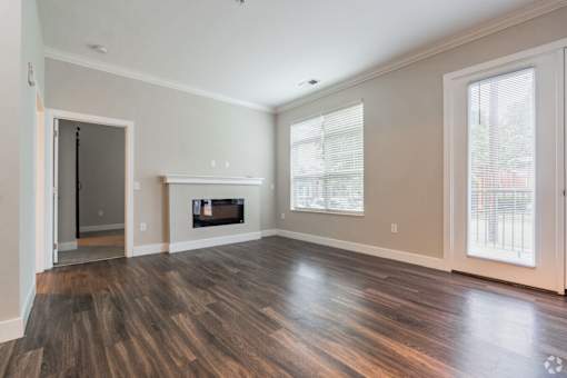 A room with a fireplace and wood flooring.